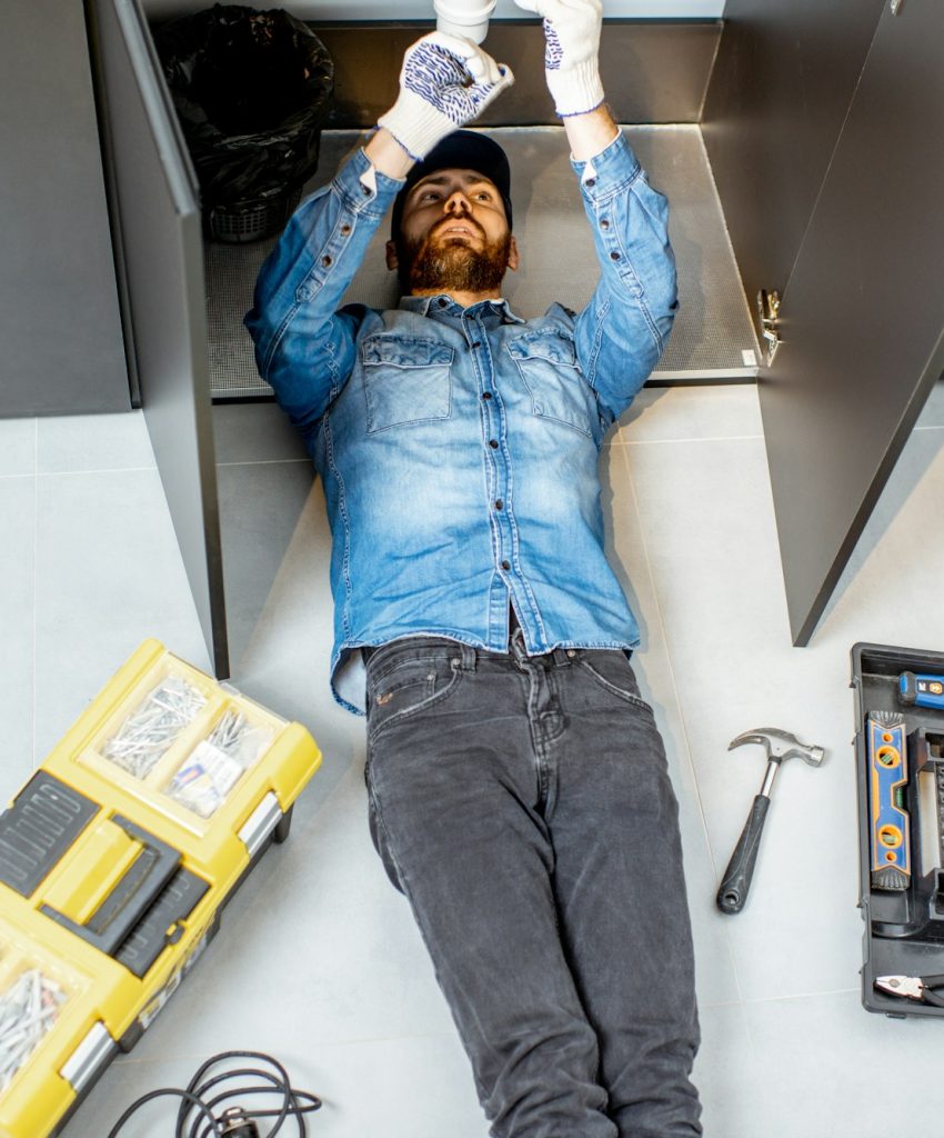 Man repairing kitchen plumbing